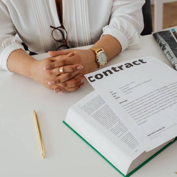 Iemand bekijkt een contract met documenten op een bureau (1)