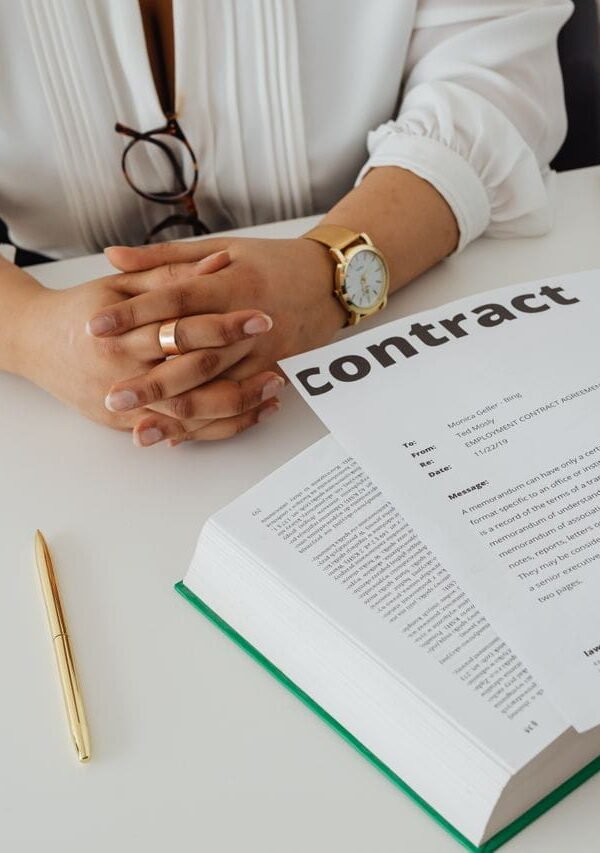 Iemand bekijkt een contract met documenten op een bureau (1)