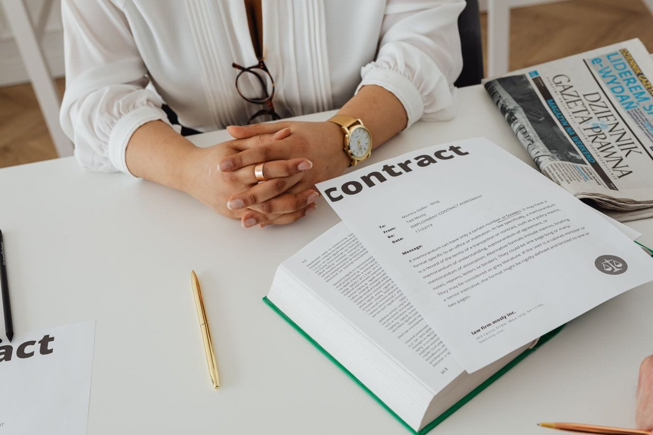 Iemand bekijkt een contract met documenten op een bureau (1)
